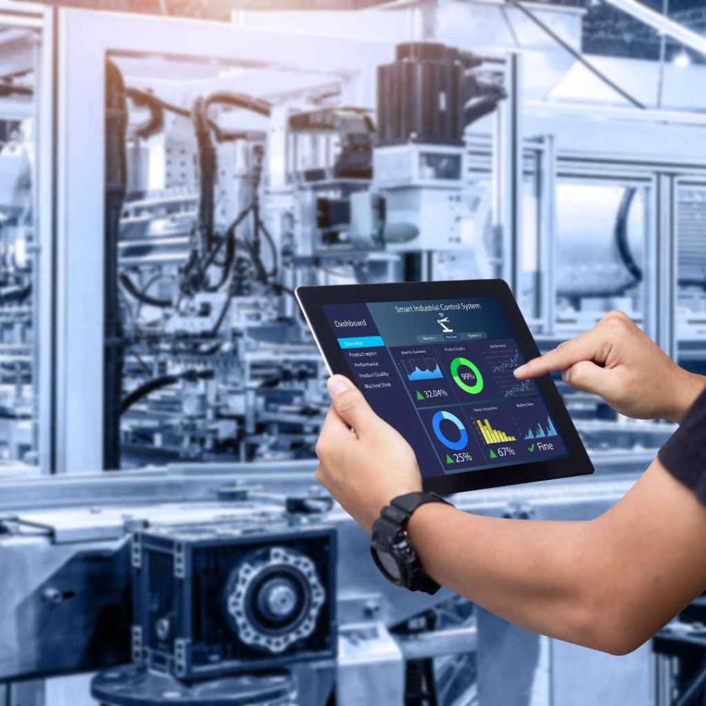 BENCOR's smart manufacturing: an engineer monitors a Siemens Smart Industrial Control System via tablet, optimizing PCB assembly and reducing costs